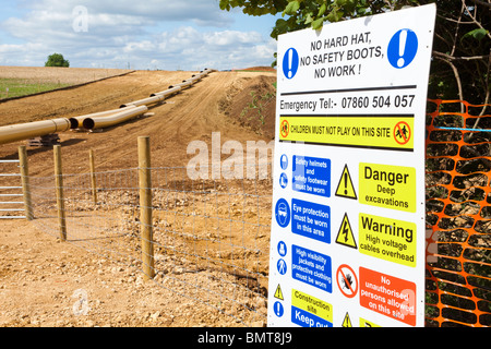 Arbeitsschutzhinweis für Industriegelände, wo eine National Grid-Pipeline verlegt wird, hier durch die Cotswolds in der Nähe von Coberley, Gloucestershire, Großbritannien Stockfoto