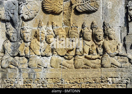 Indonesien-Java-Borobudur, sitzende Figuren mit gefalteten Händen vor dem König (nicht im Bild). Stockfoto