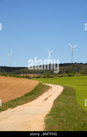 ländliche Strecke durch Weizen Felder Windkraftwerke auf dem Horizont, in der Nähe von Huete, Cuenca Provinz Kastilien-La Mancha, Spanien Stockfoto