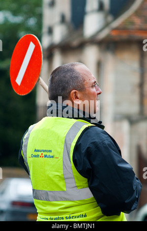 Mann mit temporären Stop Schild bei Radrennen - Frankreich. Stockfoto