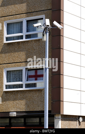 Überwachungskameras außerhalb einem Wohnblock mit englischer Flagge im Fenster Stockfoto