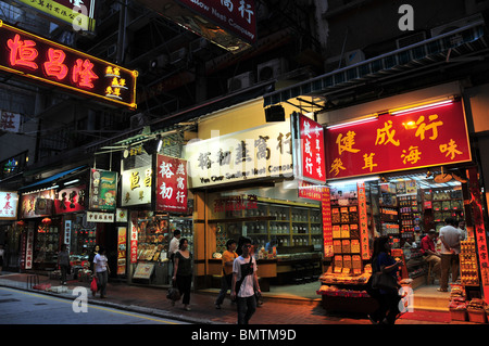 Nächtliche, schrägen Blick auf sechs Neon beleuchtet, Trockenfutter und chinesische Medizin Shops, Wing Lok Street, Sheung Wan, Hong Kong Stockfoto