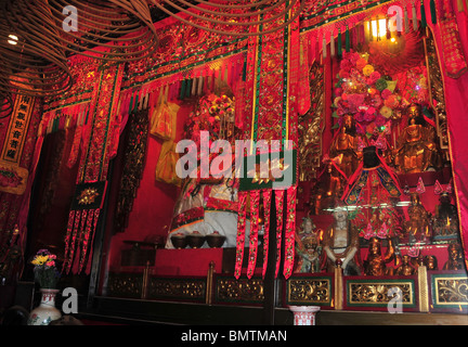 Nahaufnahme des Goldes Göttin der Barmherzigkeit und andere buddhistische Figuren, rote Hochaltar der Kwun Yam Temple, Sheung Wan, Hong Kong Stockfoto