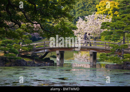 Die gewölbte Nakajima Brücke kreuzen über die Gezeiten Meerwasser von Shioiri Teich innen Hama-Rikyu Garten, von der Bucht von Tokio im Zentrum von Tokio, Japan. Stockfoto