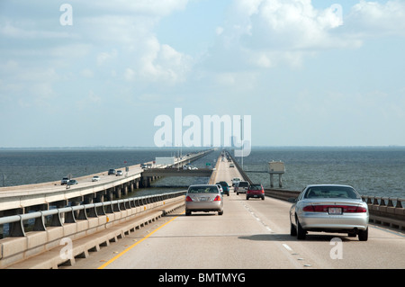 Autos fahren in südlicher Richtung auf der Causeway über den Lake Pontchartrain mit Metairie, einem Vorort von New Orleans, in der Ferne, Louisiana, USA. Stockfoto