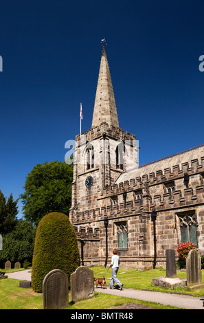 Großbritannien, England, Derbyshire, Peak District, Hathersage, Frau zu Fuß Hund durch St. Michael Friedhof Stockfoto