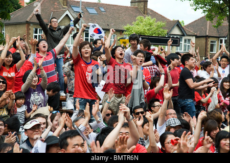 Jungen südkoreanischen Fußball-Fans feiern ihr Team erzielte gegen Griechenland in einem Londoner Pub Garten, WM 2010 Stockfoto