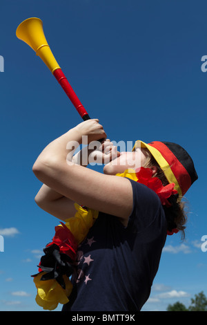 Weibliche Fußball-Lüfter bläst die vuvuzela Stockfoto