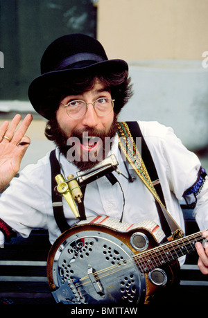 Ein talentierter Straßenmusiker spielt begeistert mit seinem Banjo, Mundharmonika, Kazoo und Pfeifen in der Französisch Quarter von New Orleans, Louisiana, USA. Stockfoto