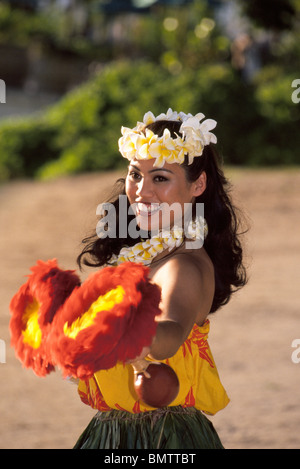 Hawaiian Hula Tänzerin führt mit Feder Kürbis Rasseln ('uli'uli) am Strand von Waikiki während einem Luau für Touristen in Honolulu, Oahu, Hawaii, USA. Stockfoto
