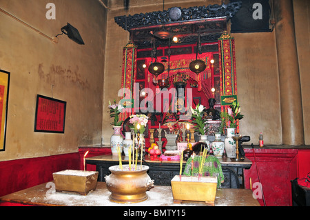 Chinesische Dame mit rot gold schwarz verzierte taoistische Gottheiten, Man Mo Tempel, Sheung Wan, Hong Kong in einem hell erleuchteten Schrein beten Stockfoto