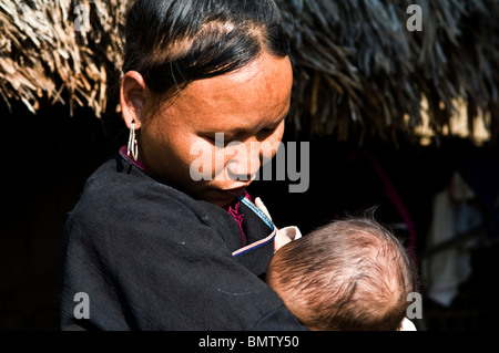 Lanten Yao Frau mit ihrem Baby. Lanten Yao Frauen zupfen sich ihre Augenbrauen. Lanten Yao Leben im Norden Laos & Yunnan Stockfoto