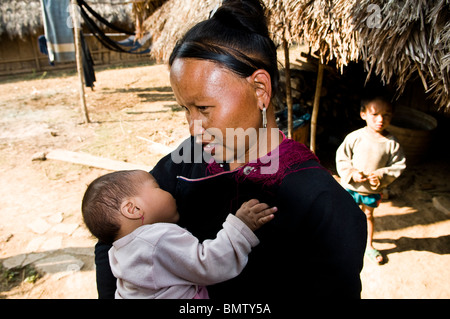 Lanten Yao Frau mit ihrem Baby. Lanten Yao Frauen zupfen sich ihre Augenbrauen. Lanten Yao Leben in Nord-Laos & Yunnan. Stockfoto