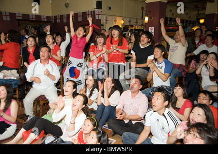 Begeistert südkoreanische Fußballfans beobachten ihre 2010 World Cup Team spielen in einem Londoner Pub, UK Stockfoto