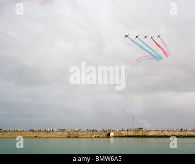 Hawk Flugzeuge von der "Red Arrows" der britischen Royal Air Force Kunstflugstaffel Anzeige über Guernsey Hafen Massen. Stockfoto