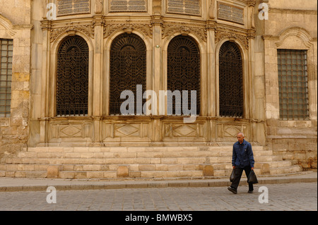 alte ägyptische Mann zu Fuß vorbei an einer der vielen Moscheen im islamischen Kairo, am frühen Morgen Szene, islamische Kairo, Kairo, Ägypten Stockfoto