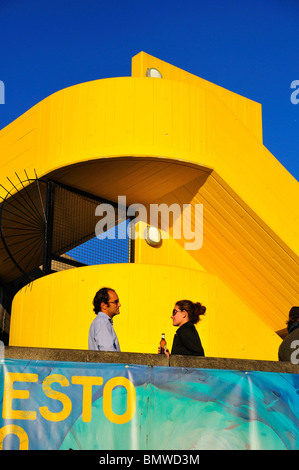 Menschen, die Geselligkeit, trinken auf dem Balkon mit abstrakten gelbe Treppe Stockfoto