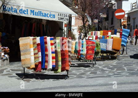 Lokal hergestellte Teppiche zum Verkauf in der Haupteinkaufsstraße Pampaneira, Las Alpujarras, Provinz Granada, Andalusien, Spanien, Europa. Stockfoto