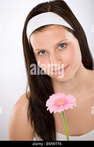 Schöne Frau, die Gerbera Daisy Blume mit weißem Stirnband Stockfoto