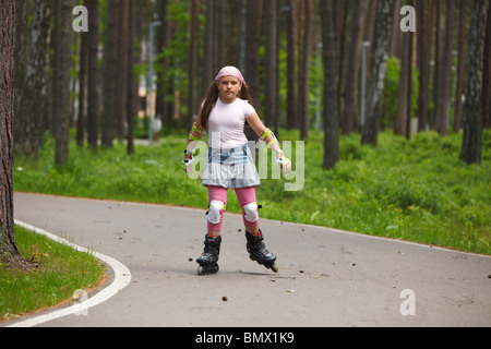 Mädchen reiten Rollerblades auf Skatingspur in einem park Stockfoto