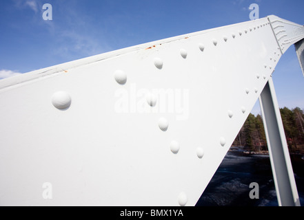 Metallträger, der mit Nieten auf der Stützkonstruktion der Eisenbrücke konstruiert wurde Stockfoto