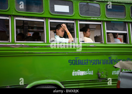 Grüne lokalen Bus auf die Straßen von Bangkok Stadt während zwei Passagiere suchen außerhalb von The Windows, Bangkok Thailand Stockfoto