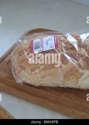 Eine frische gebackene weiße knuspriges Brot im Wrapper auf einem Brett aus Holz Brot hautnah Stockfoto