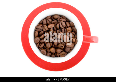 Rote Tasse und Untertasse mit Kaffeebohnen, schoss direkt von oben gefüllt. Stockfoto