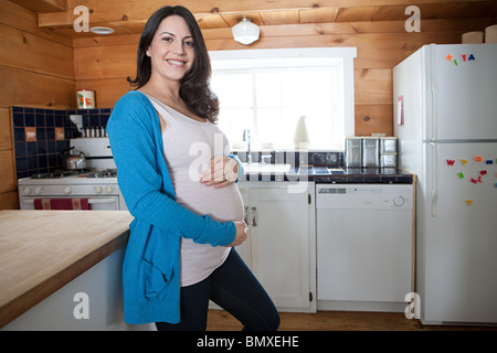 Schwangere Frau in der Küche Stockfoto