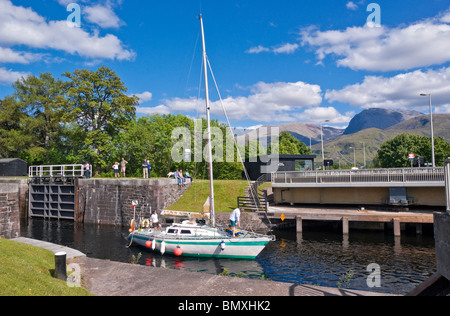 Eine Yacht ist der Caledonian Canal auf treppenartigen Fort William mit dem A830 Straße Drehbrücke geöffnet auf der Durchreise Stockfoto