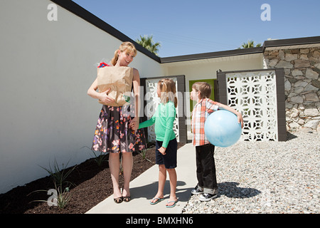 Mutter mit zwei Kindern vor Haus Stockfoto