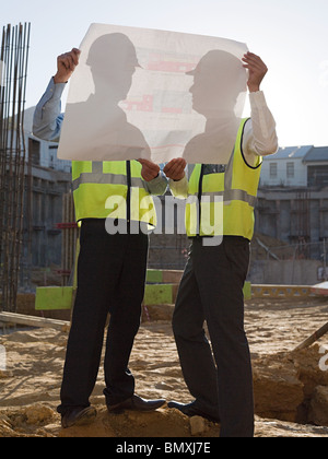 Reife Männer Inspektion Blaupausen auf Baustelle Stockfoto