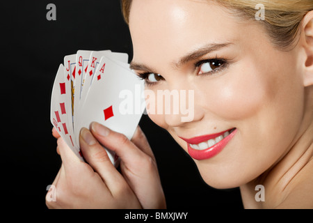 Junge blonde Frau Spielkarten Stockfoto