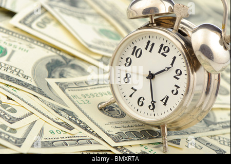 Zeit - Geld. Business-Konzept. Analoge Uhr auf einem Haufen Papier-Dollar Stockfoto