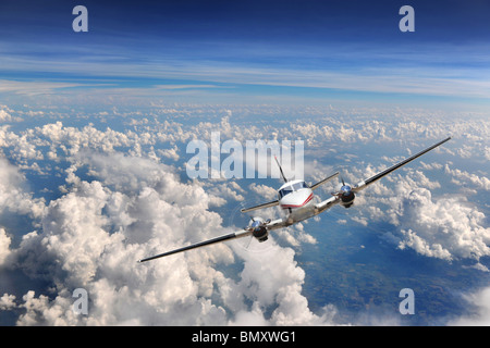 Flugzeug fliegen hoch über den Wolken Stockfoto