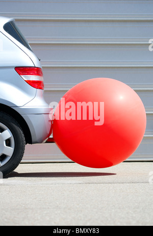 Rückseite eines Autos mit einem Ballon am Auspuffrohr Stockfoto