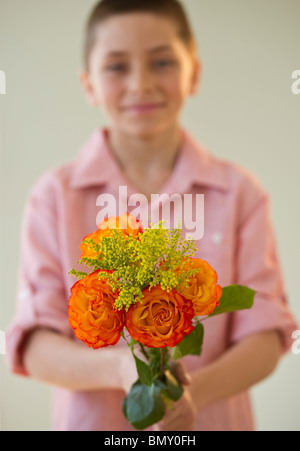 Kleiner Junge hält einen Strauß Rosen Stockfoto