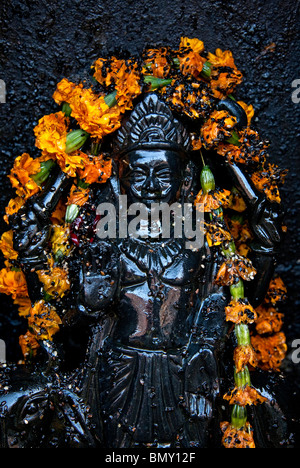 Schwarze Shiva Skulptur und Blumen Girlande. Varanasi (Benares). Indien Stockfoto