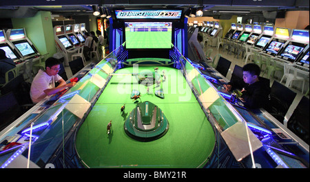 Menschen spielen auf Pferderennen Spielautomaten in einem Casino, Hong Kong, China Stockfoto