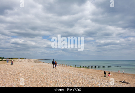 Menschen, die auf Climping Beach in West Sussex laufen. Stockfoto