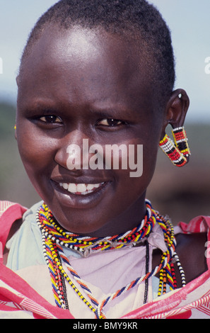 Eine Maasai Mädchen schmückt ihre gedehnten Ohrläppchen mit bunten Perlen, die Lieblings-Verzierung ihres Stammes in Kenia, Ostafrika. Stockfoto