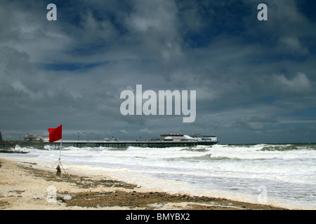 Wetter - Cromer. Eine rote Fahne, Gefahr, angibt, wie starke Winde und Meere schöne Wellen um Cromer Pier in North Norfolk zu schaffen. Stockfoto