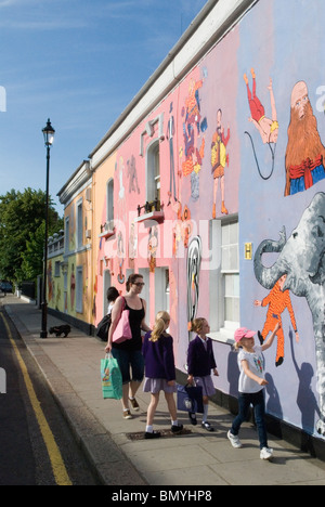 Chelsea Arts Club London UK. Familienmutterkinder gehen zur Schule, vorbei an der Renovierung ihres privaten Clubgebäudes in der Old Church Street Chelsea London. Kunstwerke Wandbilder von Tony Common. Temporäres Wandgemälde England HOMER SYKES aus den 2010 2010er Jahren Stockfoto