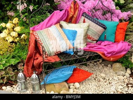 Bunte Kissen auf eine Gartenbank Stockfoto