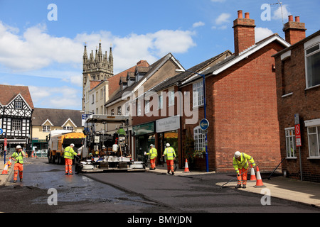 Eine Verlegung von Maschine und Männer bei der Arbeit, die Erneuerung der Straße im Brook Street, Warwick asphalt Stockfoto
