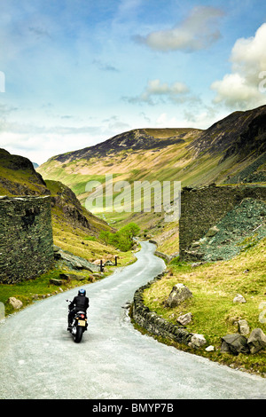 Motorradfahrer auf Straße Reise durch einen Berg Straße über Honister Pass im Lake District, England, Großbritannien Stockfoto