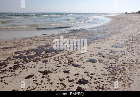 Ölpest am Strand mit off Shore Bohrinsel im Hintergrund. Stockfoto