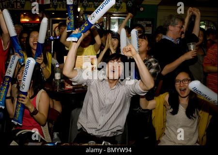 Südkoreanischen Fußball-Fans feiern ihr Team erzielte gegen Nigeria bei der WM 2010 in einem Londoner Pub Stockfoto