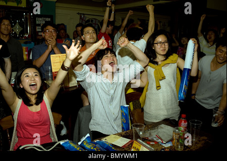 Südkoreanischen Fußball-Fans feiern ihr Team erzielte gegen Nigeria in einem Londoner Pub, während der WM 2010 Stockfoto