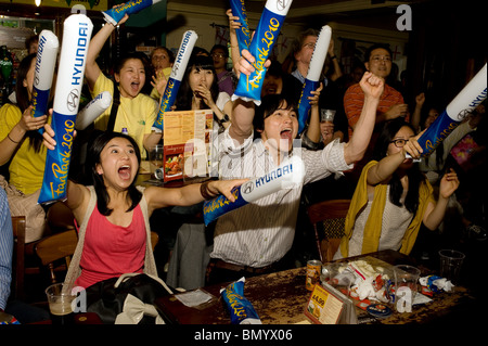 Südkoreanischen Fußball-Fans feiern ihr Team erzielte gegen Nigeria bei der WM 2010 in einem Londoner Pub, Stockfoto